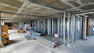 Interior shot of the Parcel 4 building under precise construction by Robey's skilled team, with metal framing and construction materials systematically arranged.
