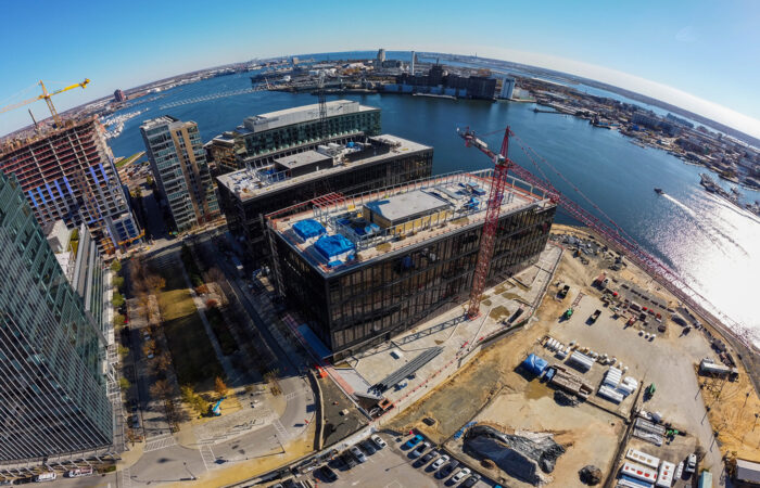 Aerial drone shot of crane by two buildings downtown